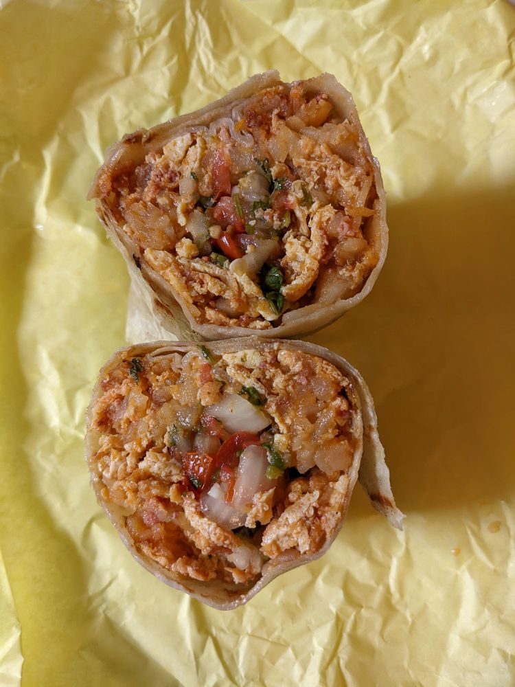 Pete's Blue Chip breakfast burrito cut in half, showing eggs, potatoes, meat and pico de gallo